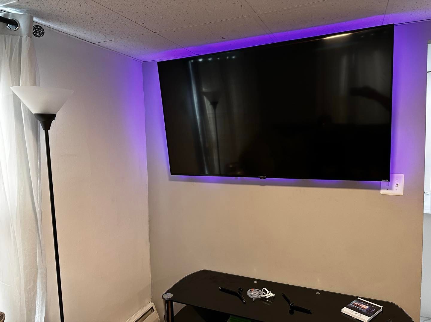 A flat screen tv is mounted to the wall in a living room