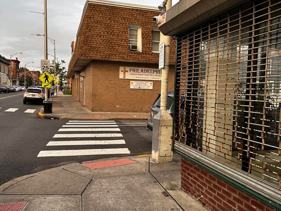 A crosswalk in front of a building with a sign that says ' pelaw ' on it