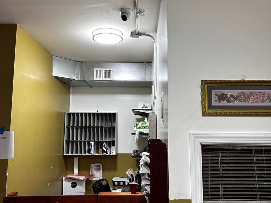 A room with a ceiling light and a picture on the wall.