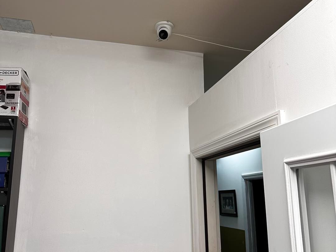 A room with a door and a camera on the ceiling