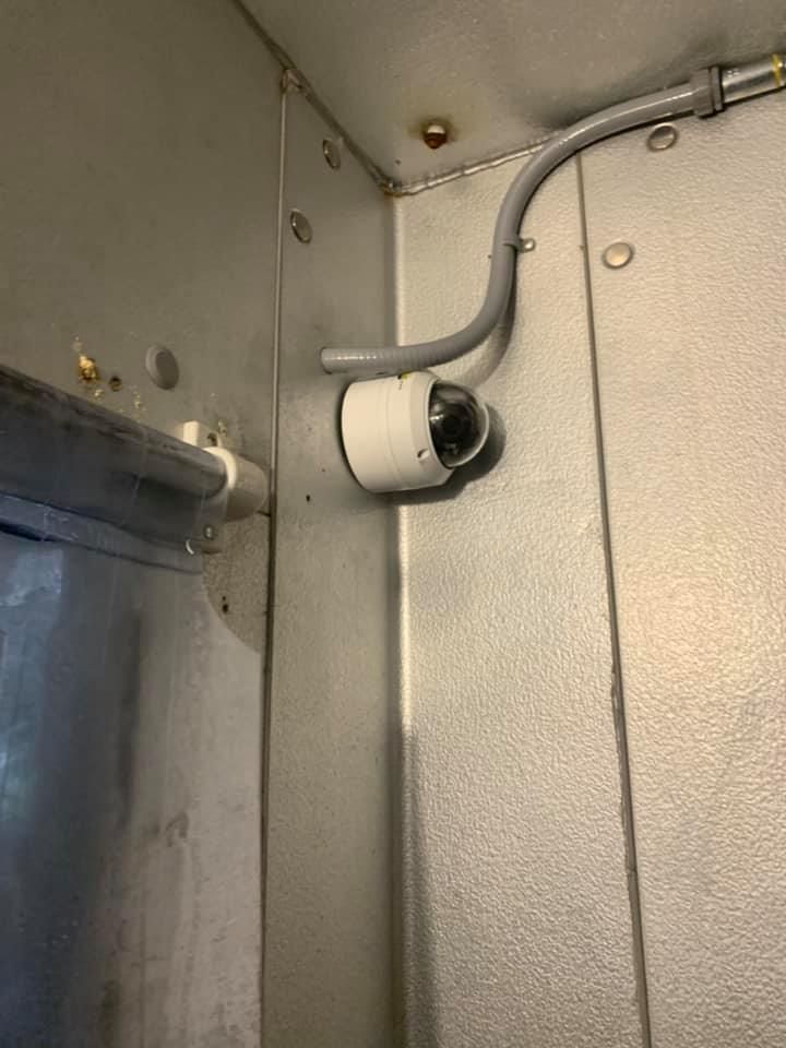 A close up of a metal wall with a hose attached to it.