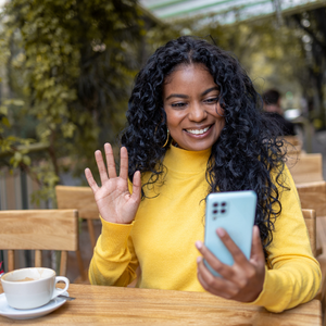 woman waving at her phone