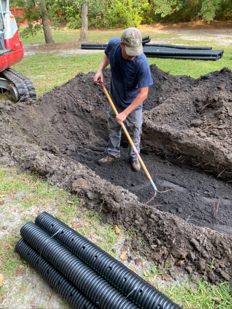 a man is digging in the dirt with a rake