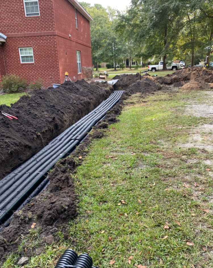 a large pile of dirt and pipes in front of a brick house