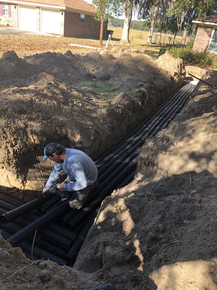 a man is working on a drainage system in the dirt