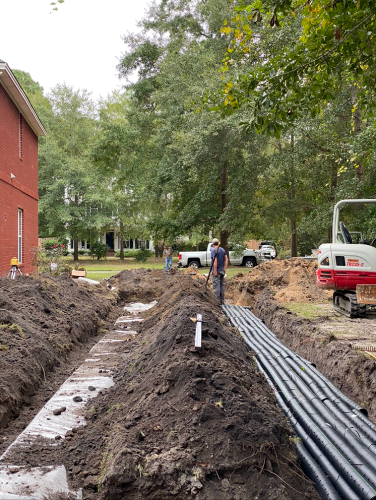 a construction site with a tbc excavator in the background