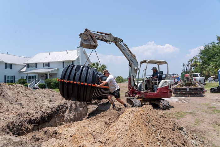 a man is lifting a large container in front of a house