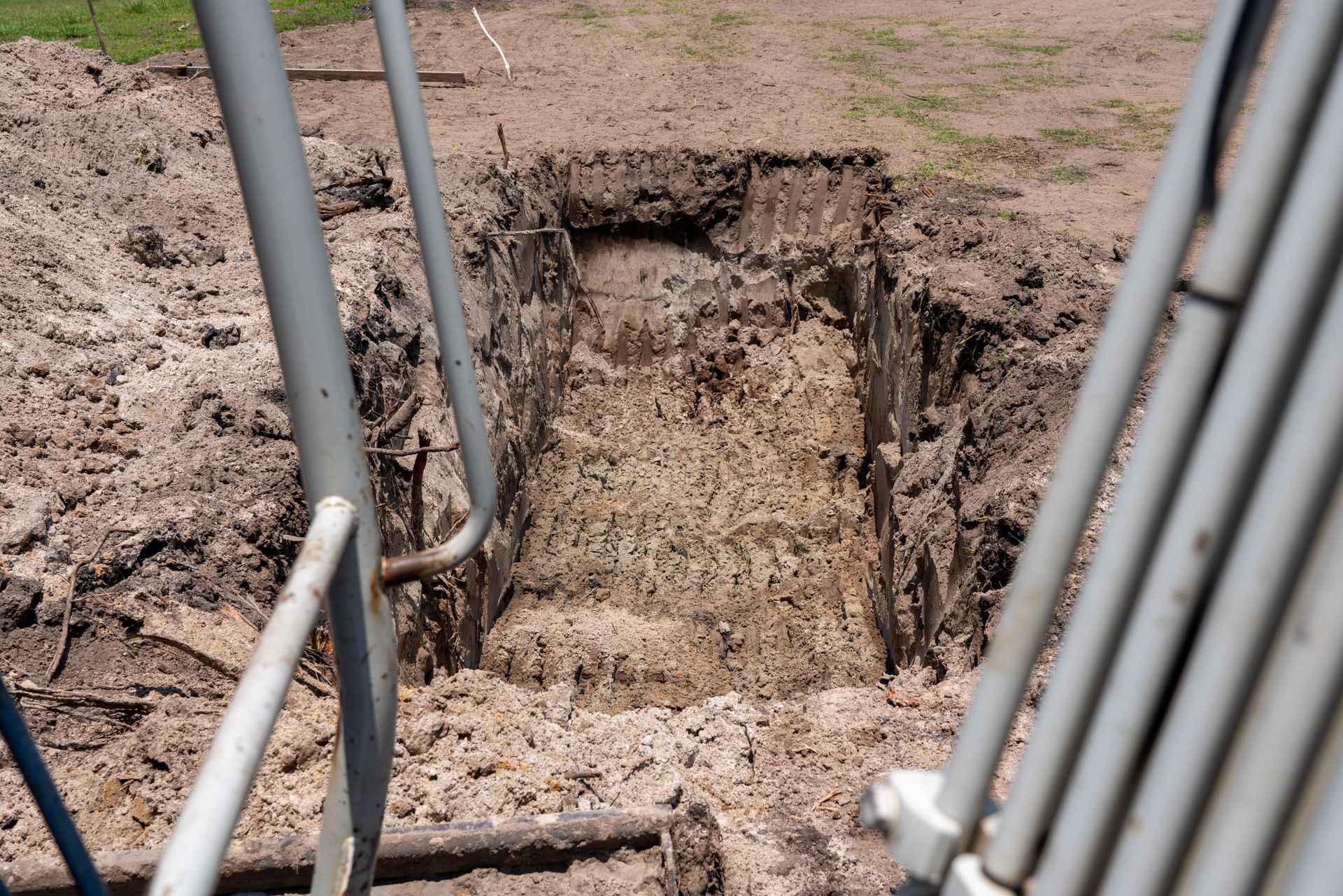 a large hole in the ground with a metal railing