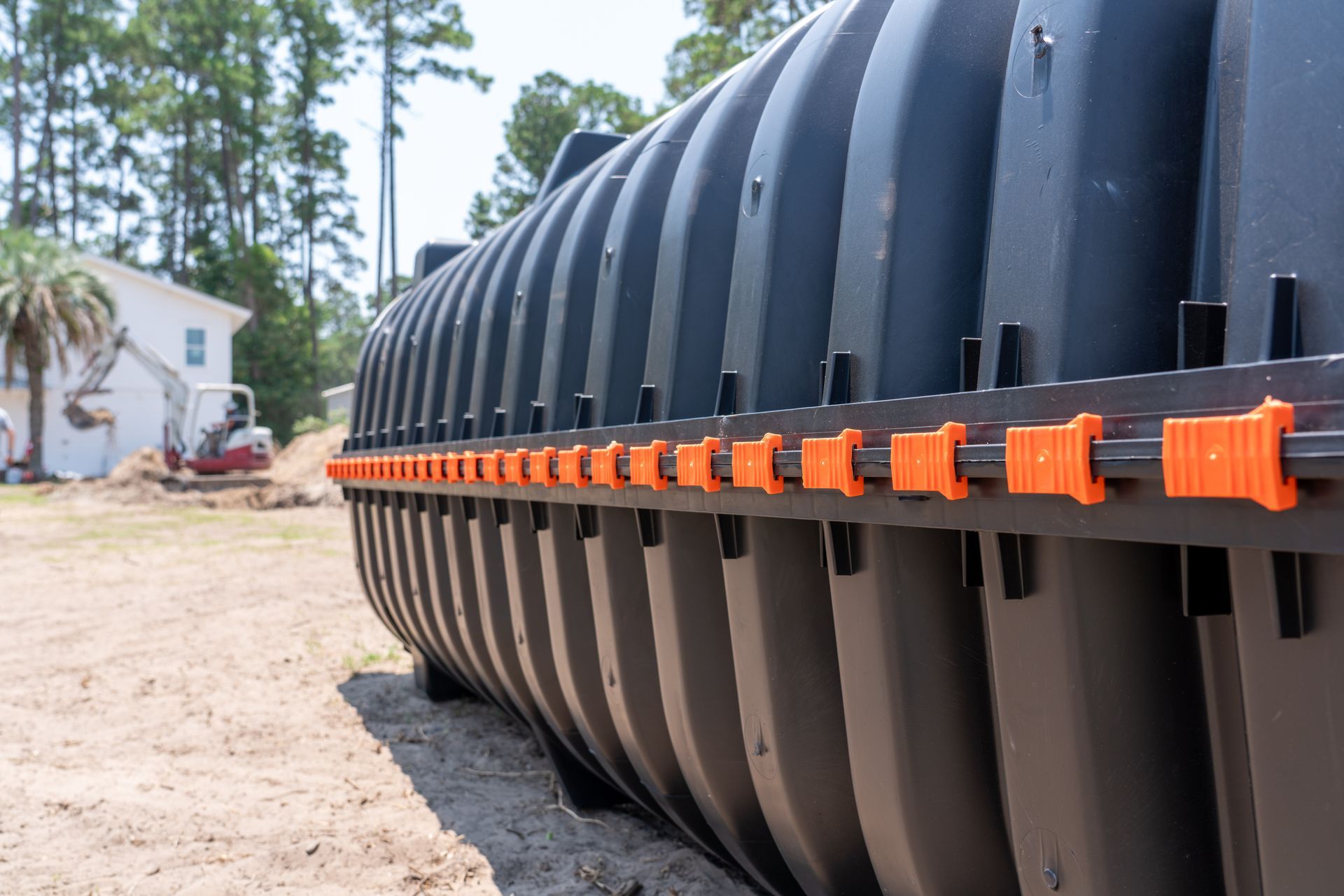 a large black tank is sitting in the dirt in front of a houseSeptic Pump Installation