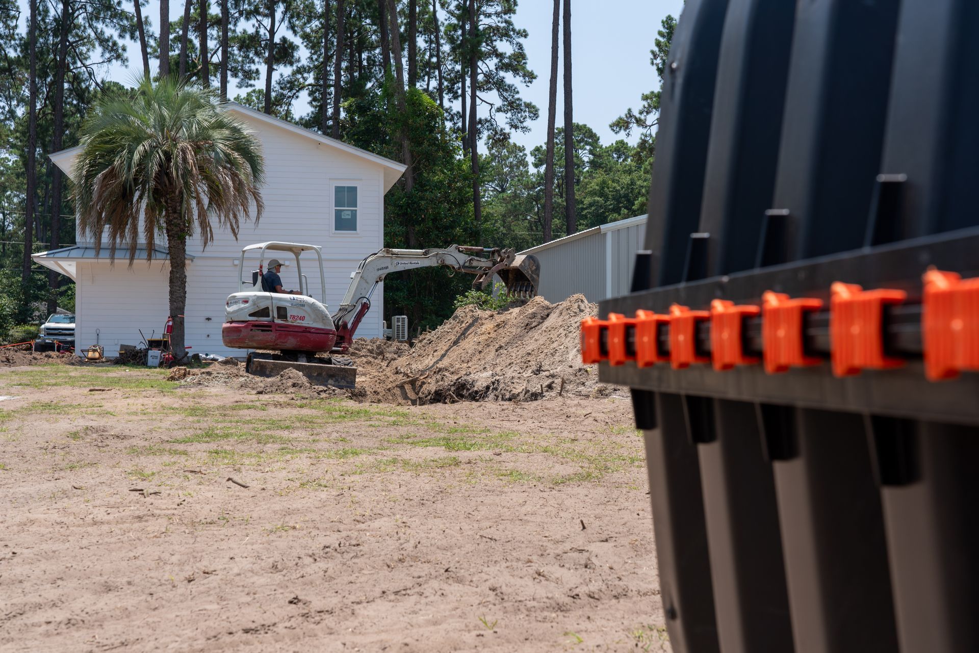 an excavator is digging a hole in front of a house
