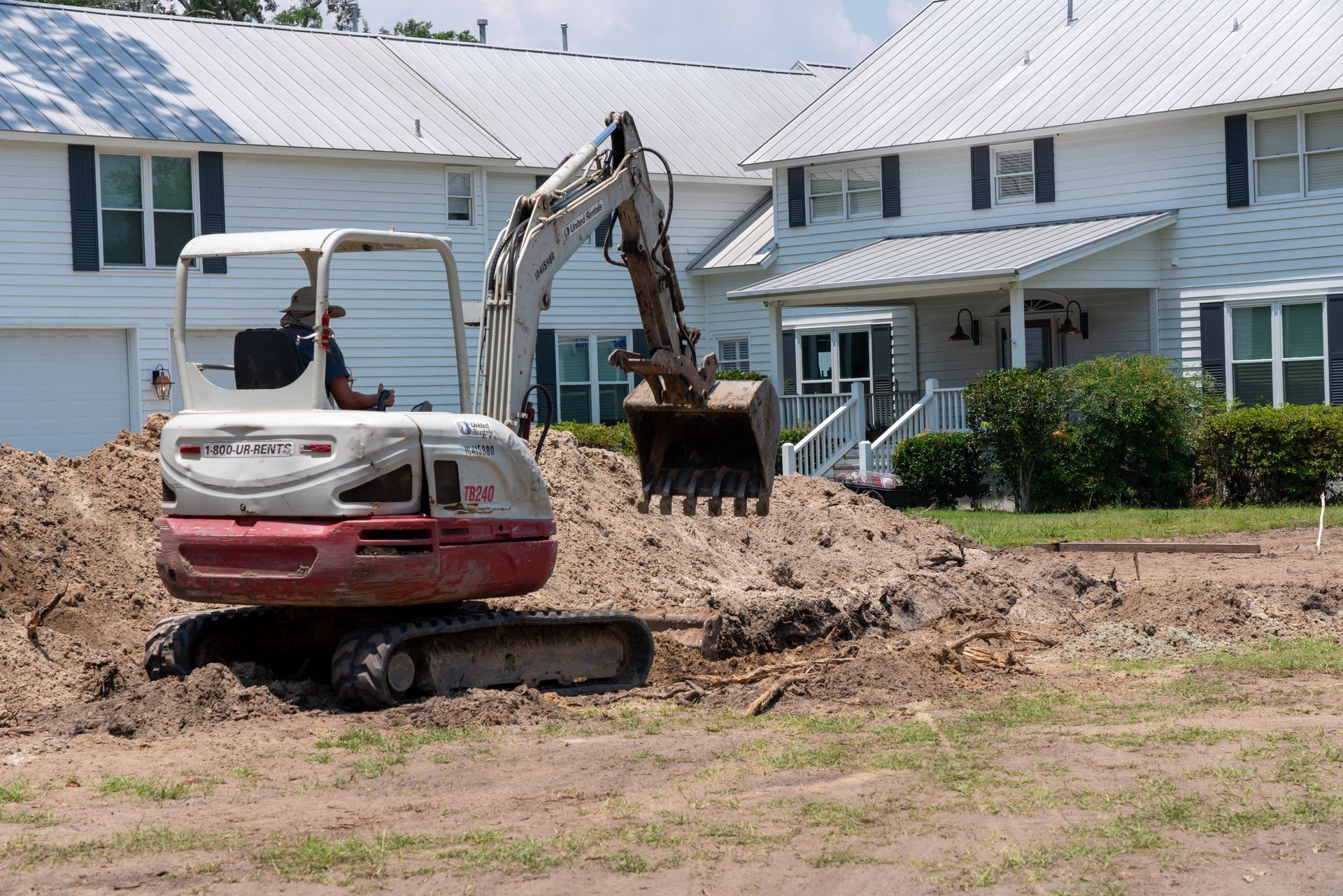 a white excavator with a bucket that says tbs on it