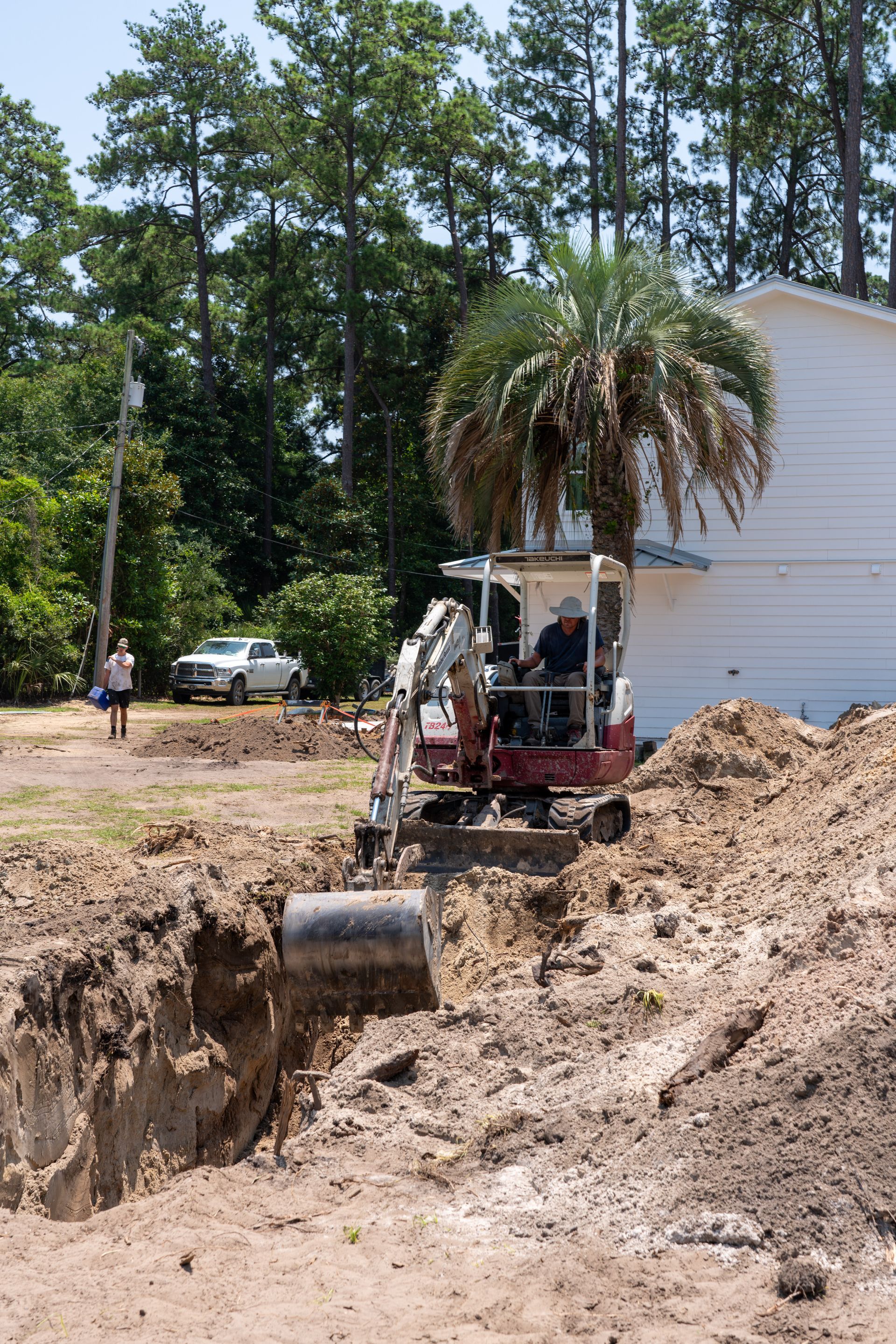a man is driving an excavator in a dirt field