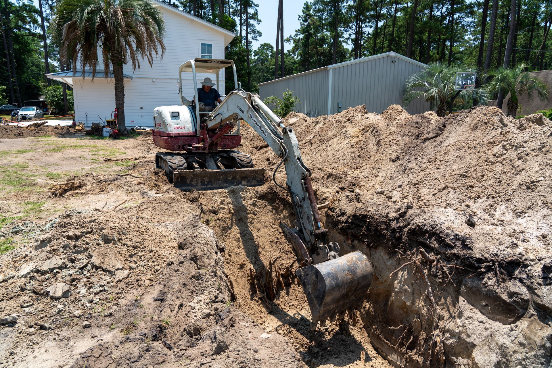 a man is digging a hole in the dirt with an excavator that says takeuchi