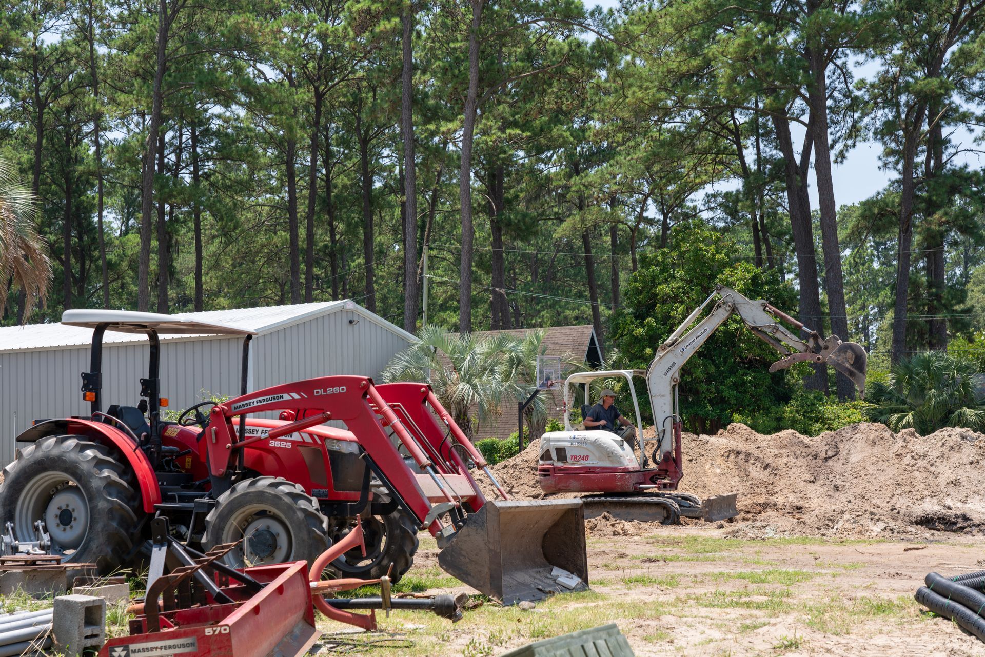 a red tractor is parked in front of a white building