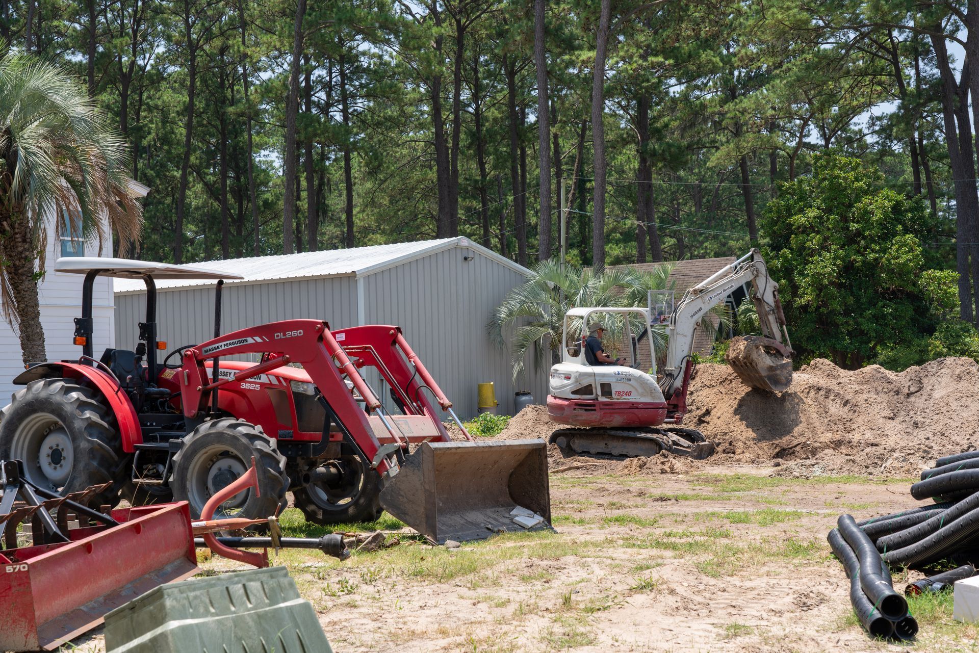 a red massey ferguson tractor is parked next to a white excavator
