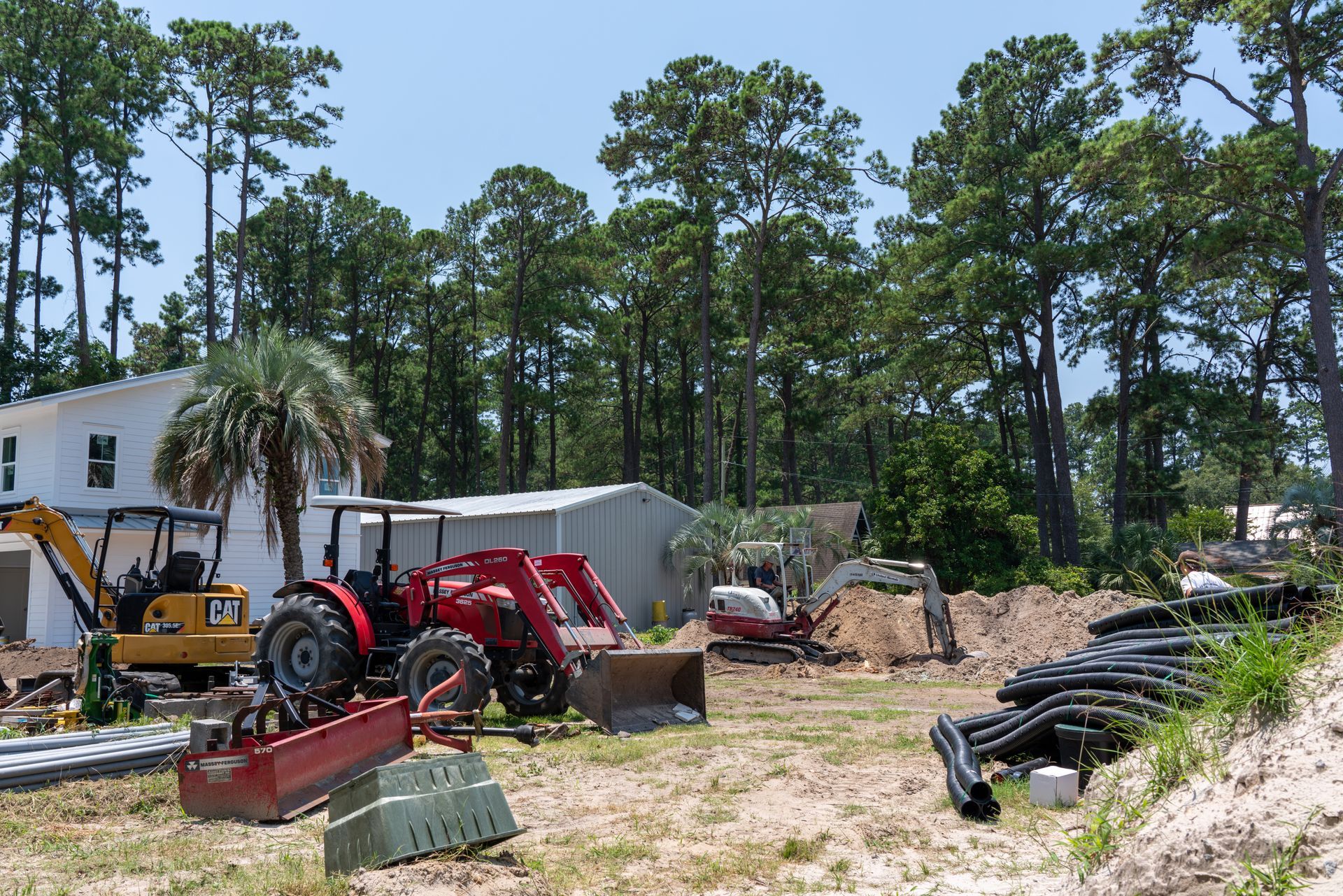 a cat tractor is parked in front of a house under construction