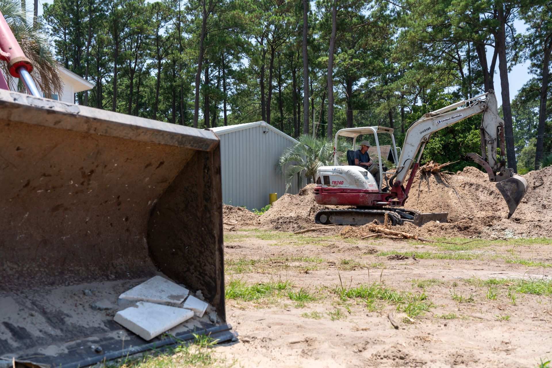 a man is driving a white and red excavator that says takeuchi