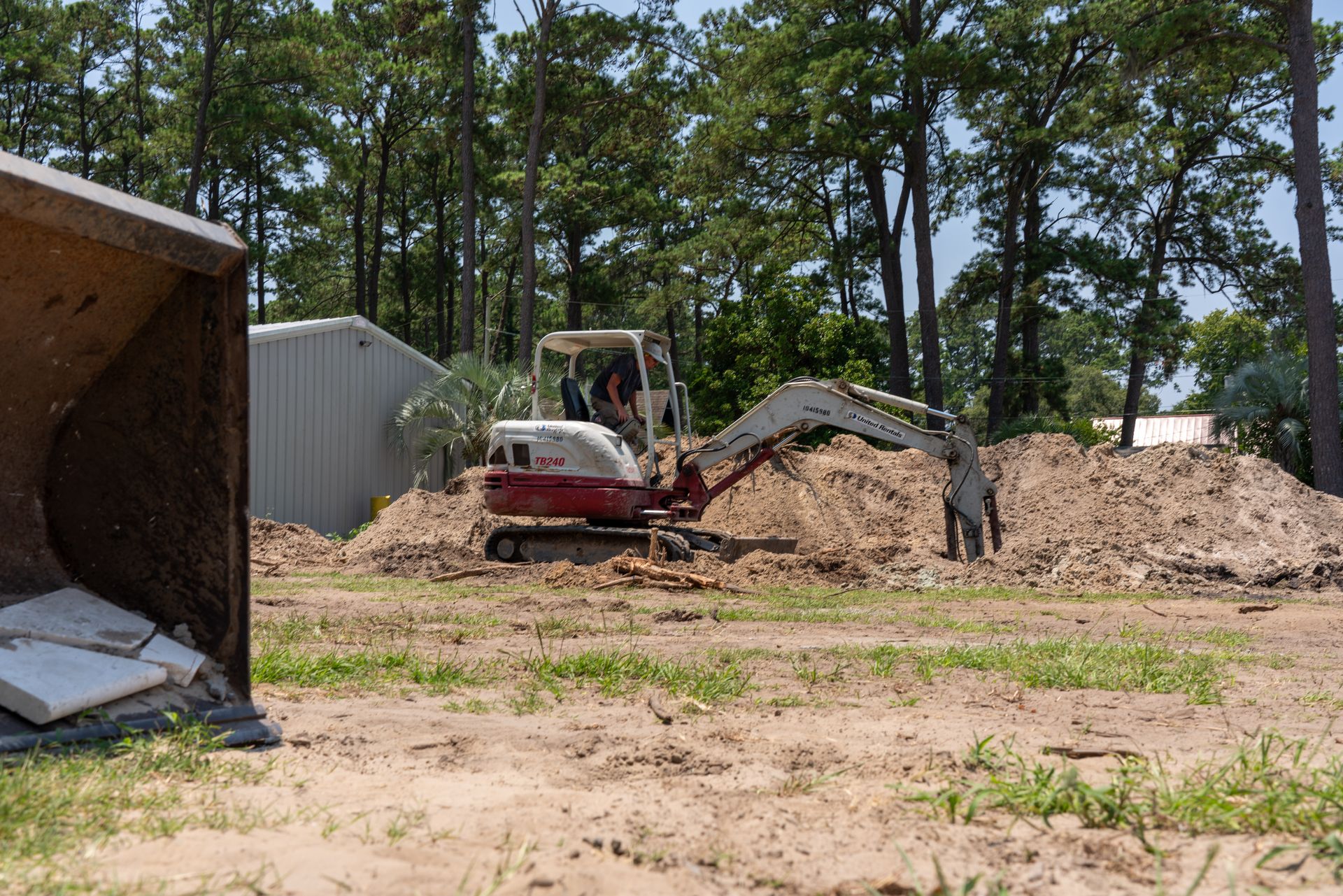 a white and red excavator with the word takeuchi on it