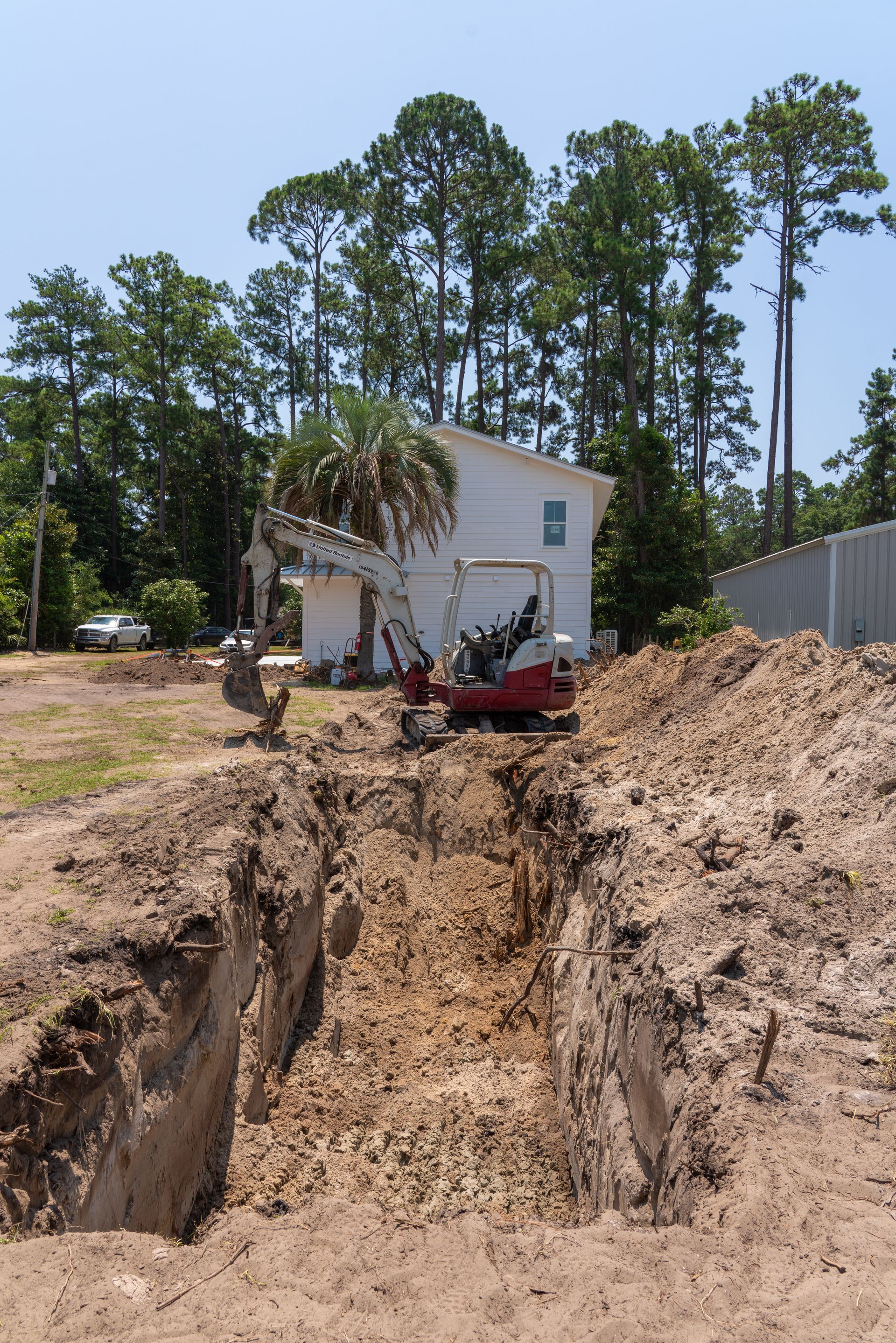 an excavator is digging a hole in front of a house