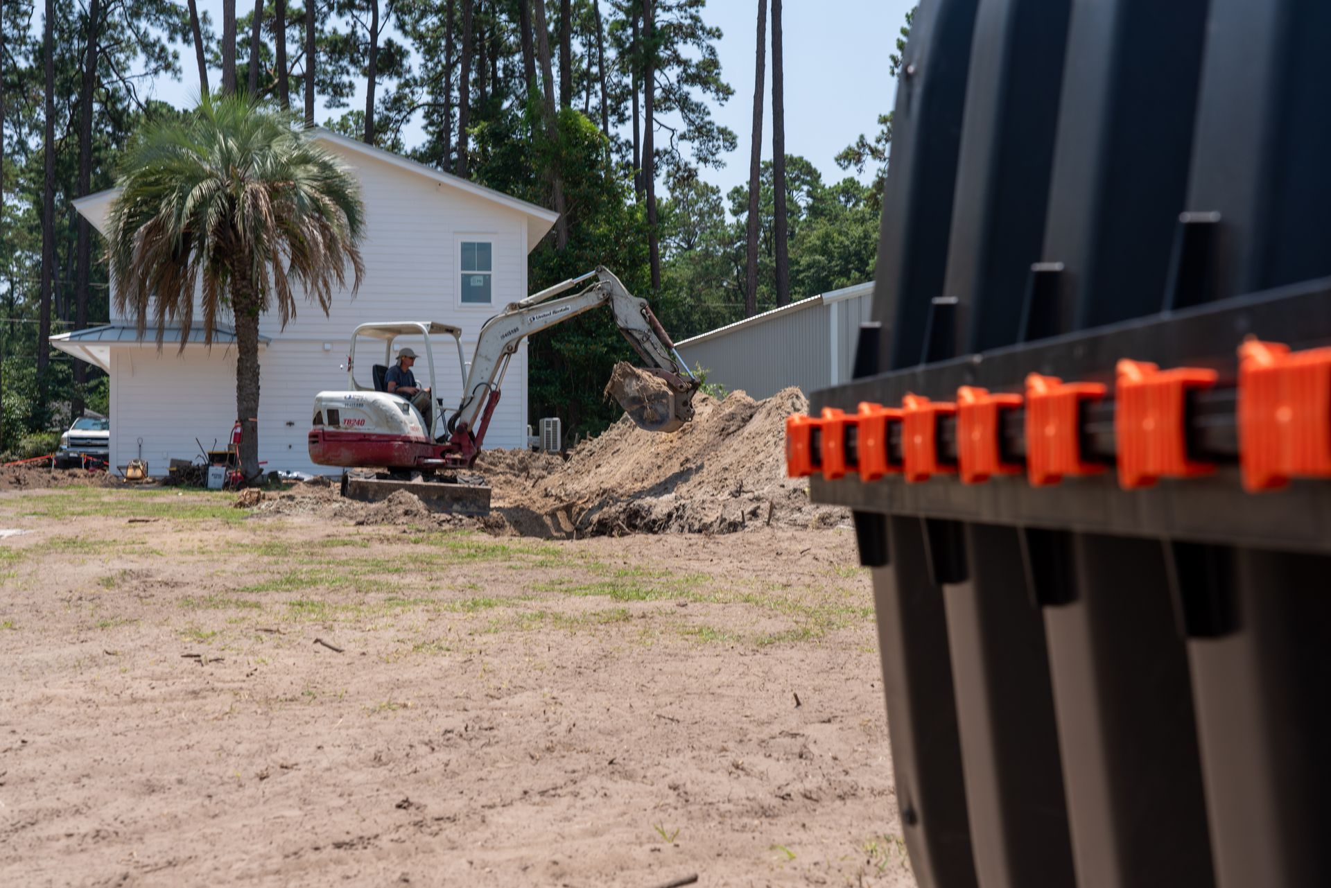 a man is driving an excavator in front of a house