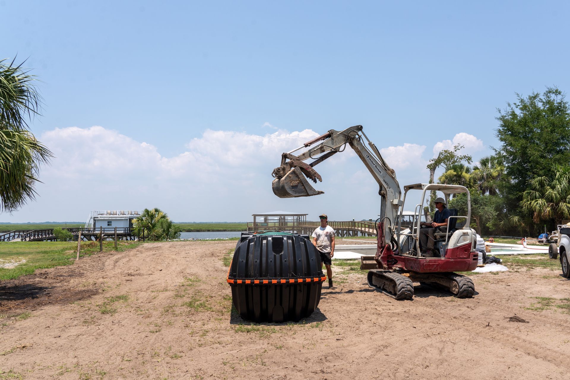 a man stands next to an excavator that says takeuchi on it