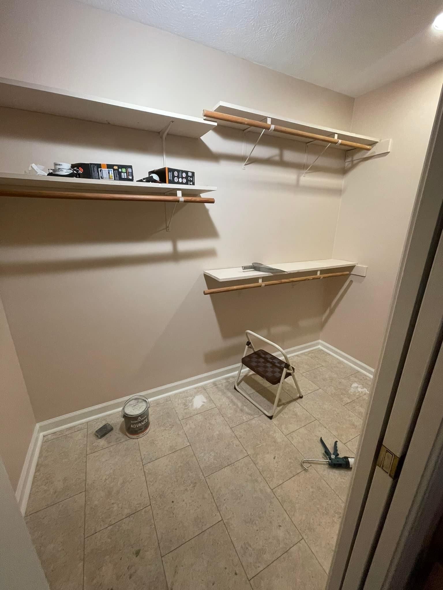 A closet with shelves and a chair in it.