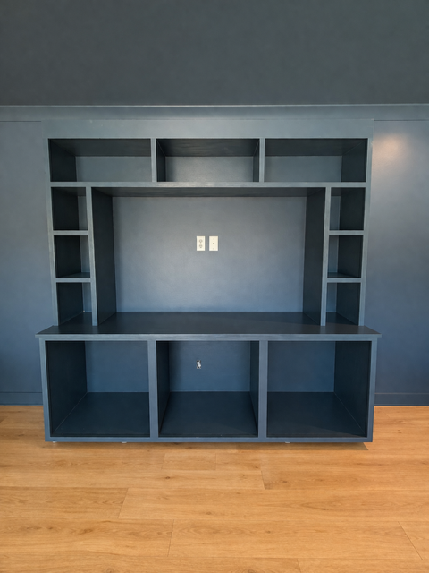 A living room with hardwood floors and a brick wall.