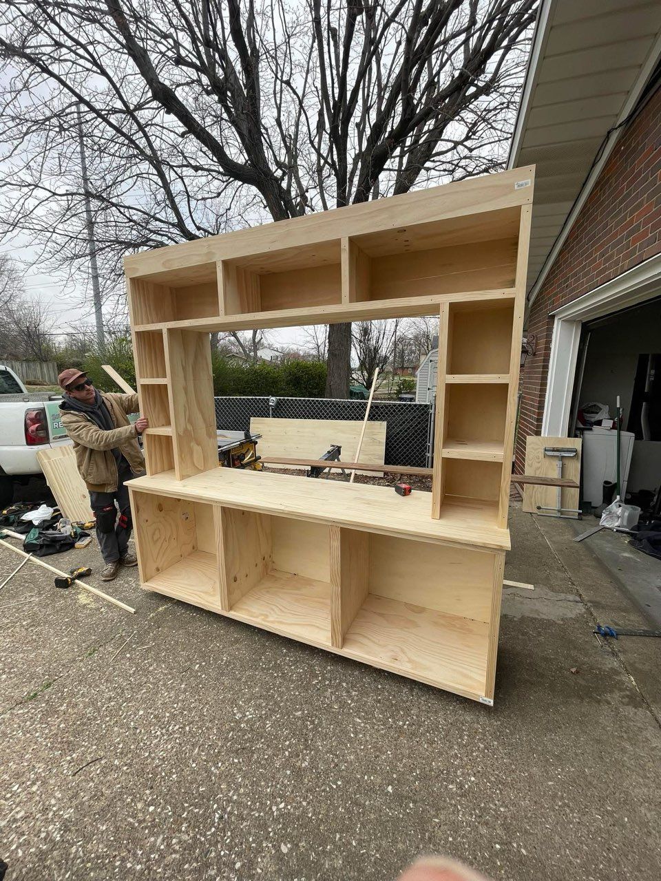 A man is working on a wooden floor in a living room.
