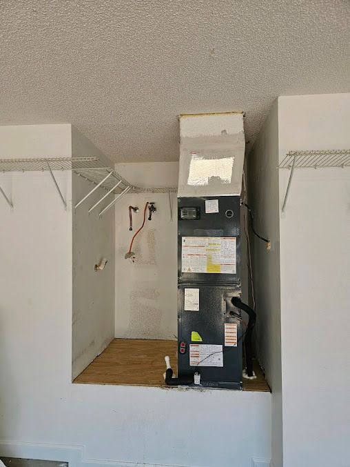 Closet with hanging rods and a tall black HVAC unit in the center, under a sloped ceiling.