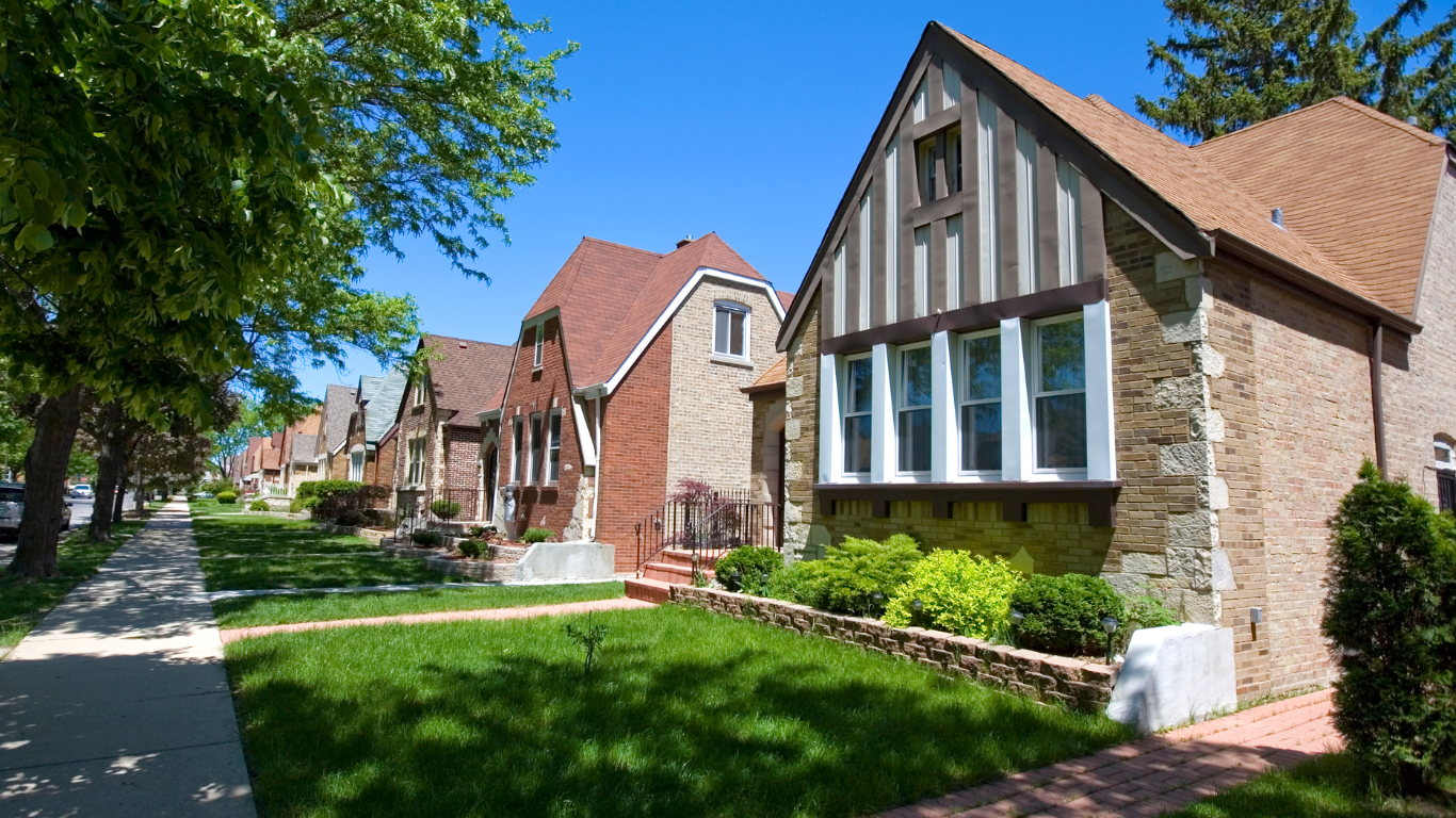 A row of houses on a sunny day with trees in the background