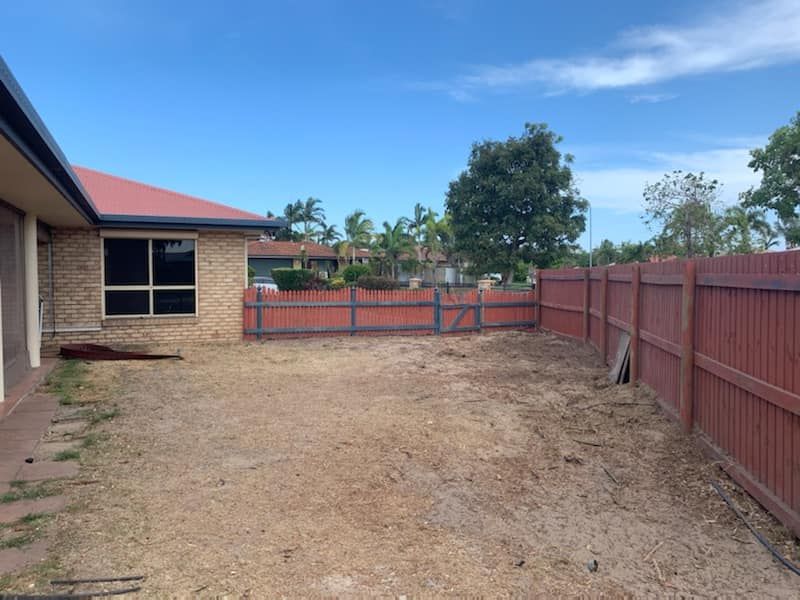 A Backyard With a Red Fence and a House in the Background — G'Days Tree Care in Habana, QLD