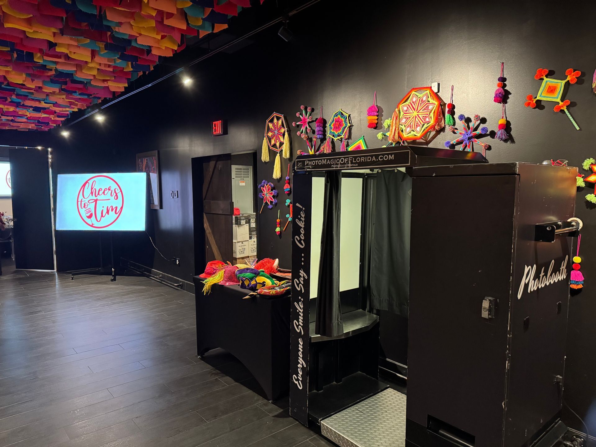 Photo booth in a room decorated with colorful paper decorations.