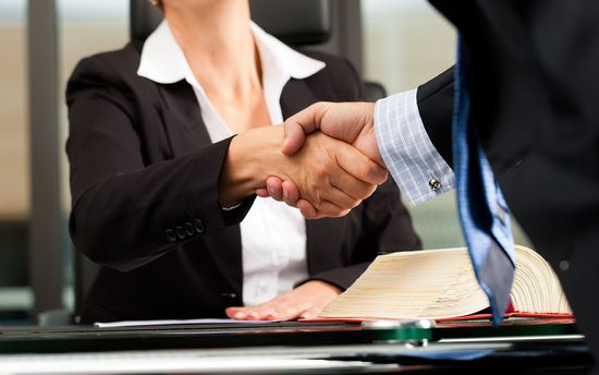 handshake between a man and woman in formal clothes