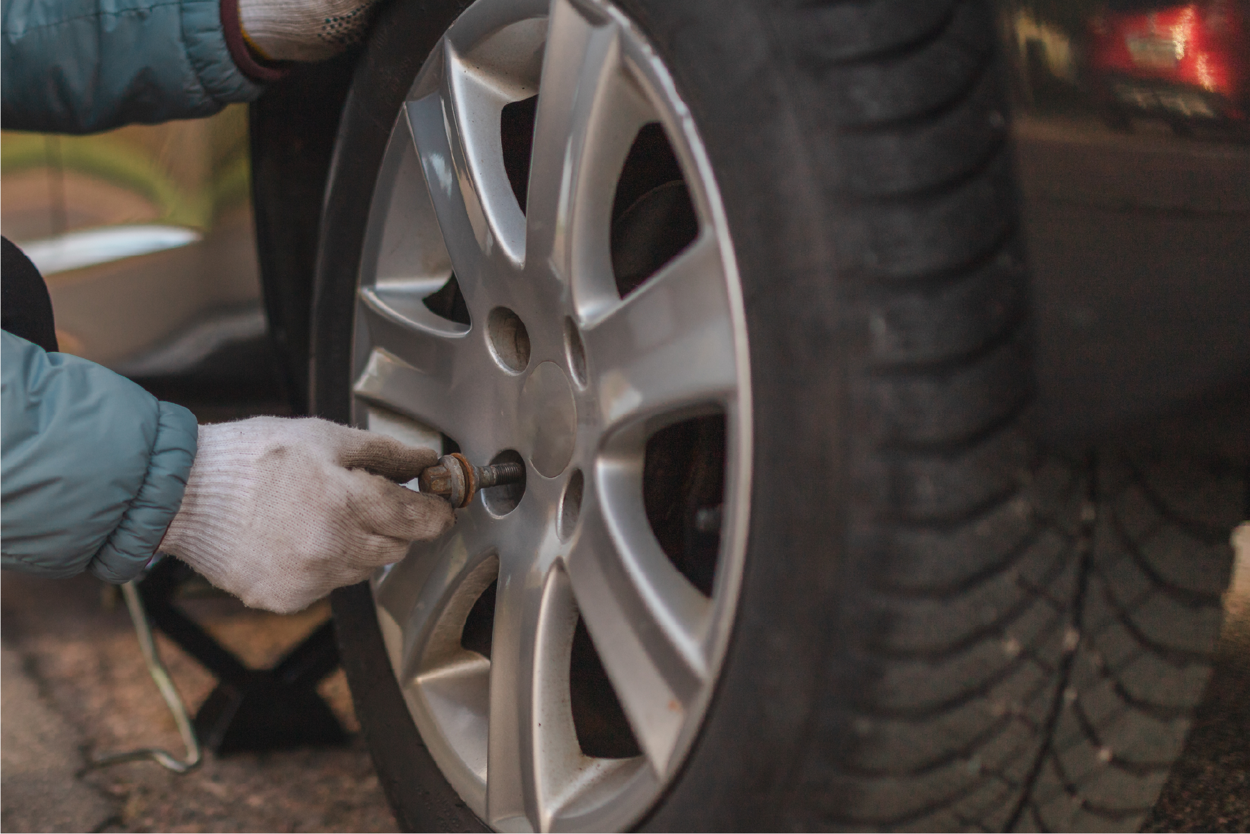 A person is changing a tire on a car.