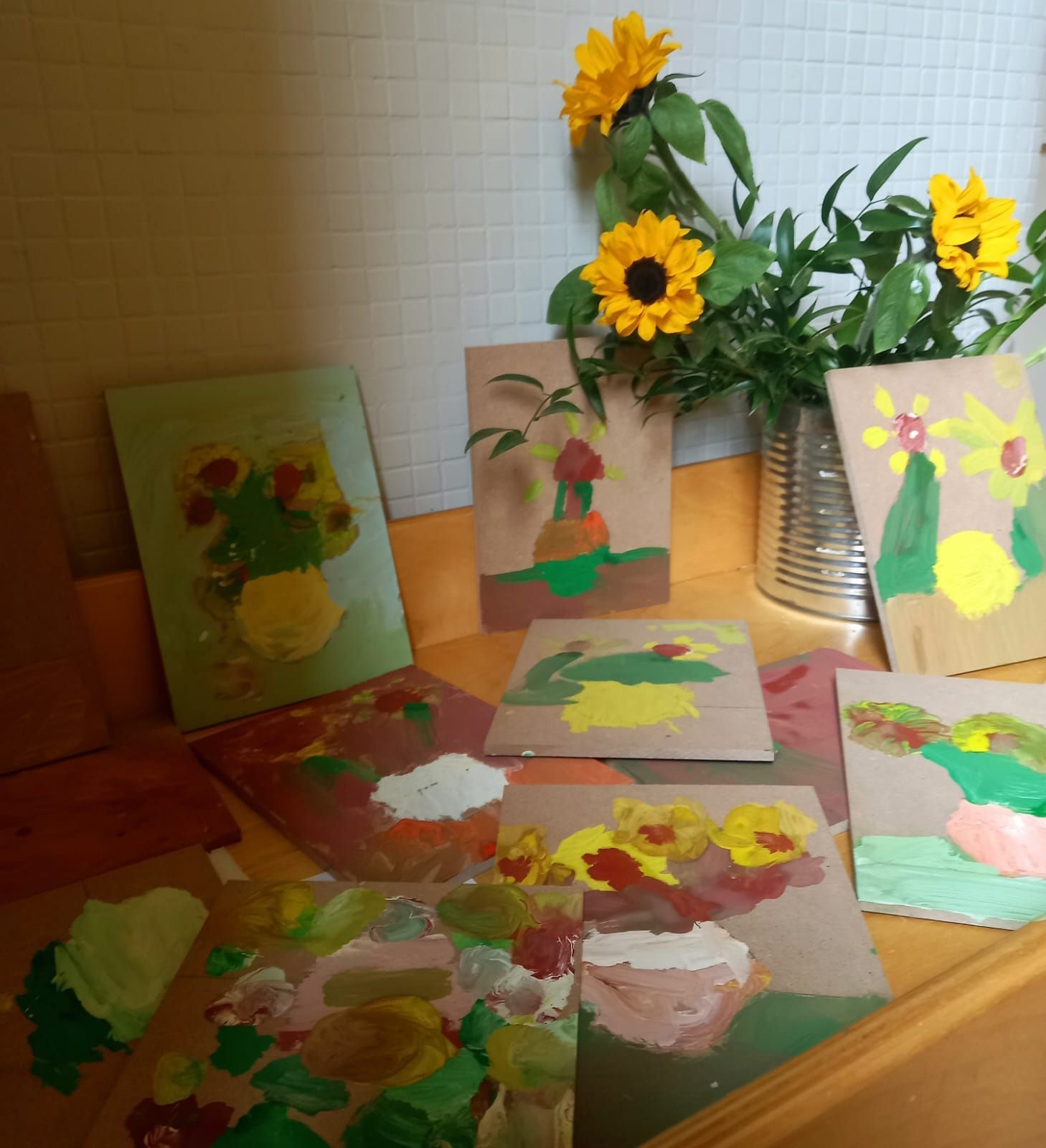 Un mucchio di dipinti su un tavolo con fiori sullo sfondo