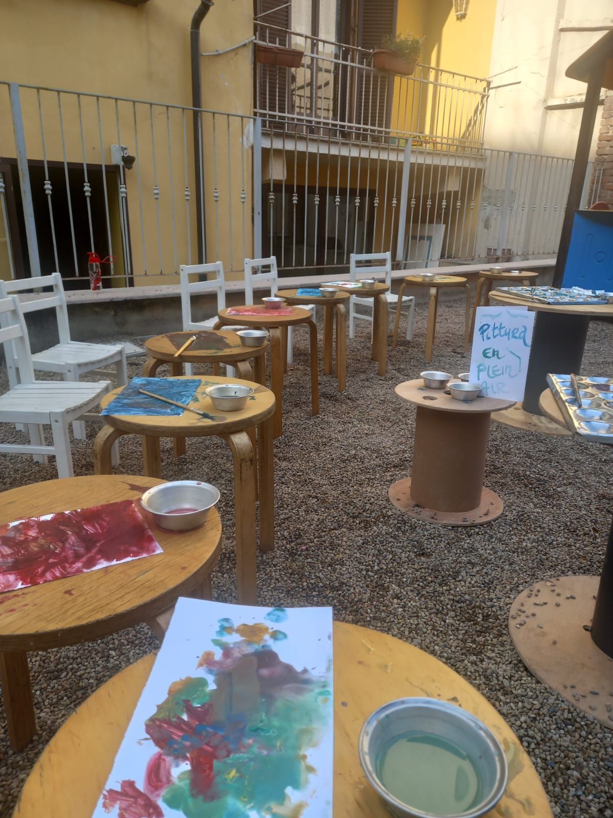 Un mucchio di tavoli con sopra delle ciotole di vernice