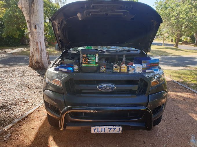 A Black Ford Truck with The Hood Open and A Bottle of Oil on The Hood — ACT Mobile Mechanics in Isaacs, ACT