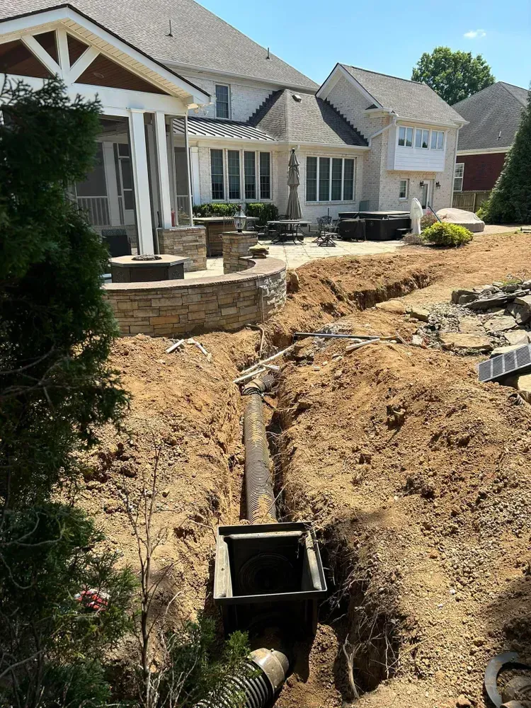 A large house is being built in the middle of a dirt field.