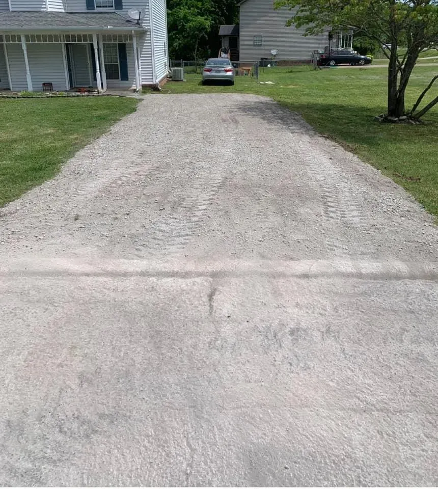 A car is parked in the driveway of a house.