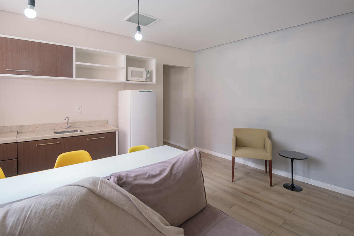 Uma sala com sofá, mesa e cadeiras.