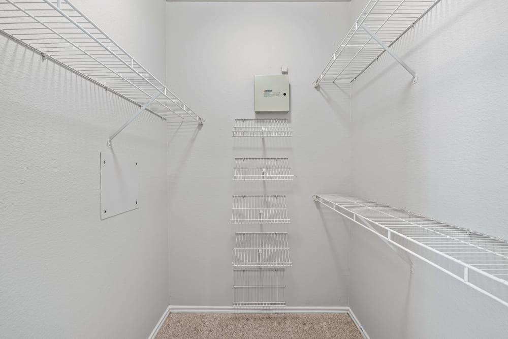 a walk-in closet with lots of shelves and a safe at Marquis at Lantana in Flower Mound, TX.