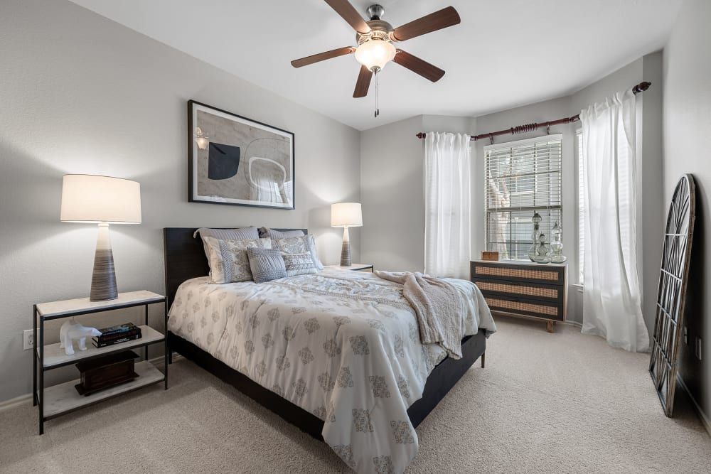 a bedroom with a large bed and a ceiling fan at Marquis at Lantana in Flower Mound, TX.