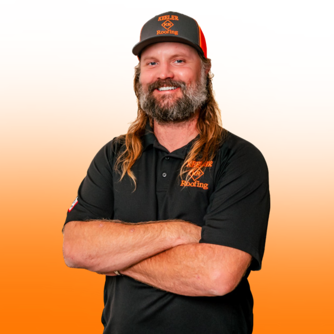 A man with long hair and a beard is wearing a black shirt and a hat.