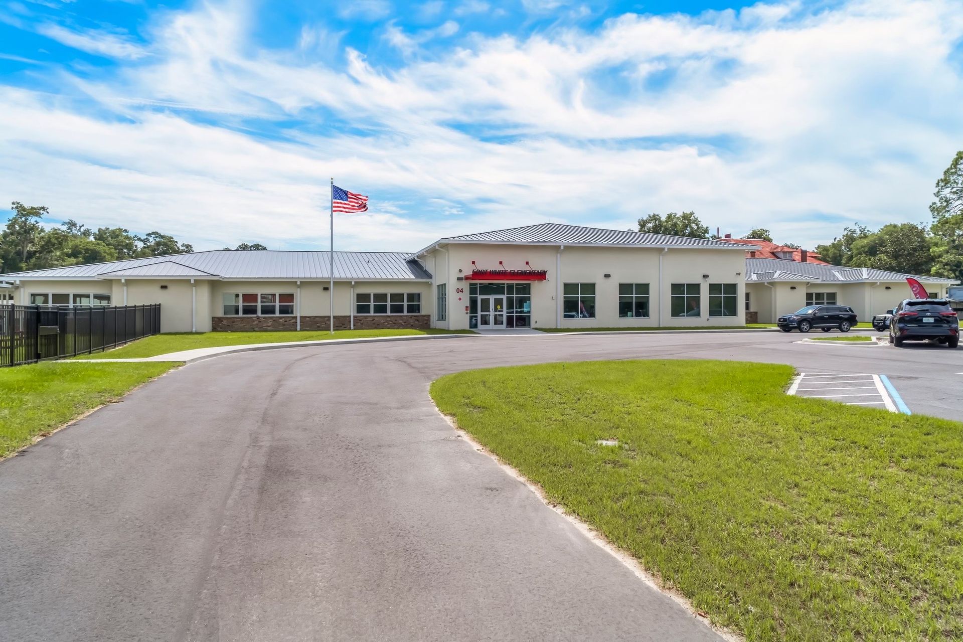 A large white building with a parking lot in front of it.