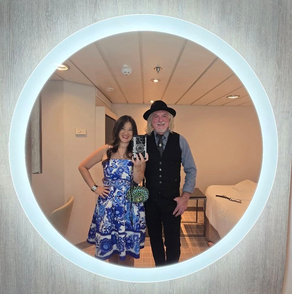 A man and a woman are taking a picture of themselves in a mirror