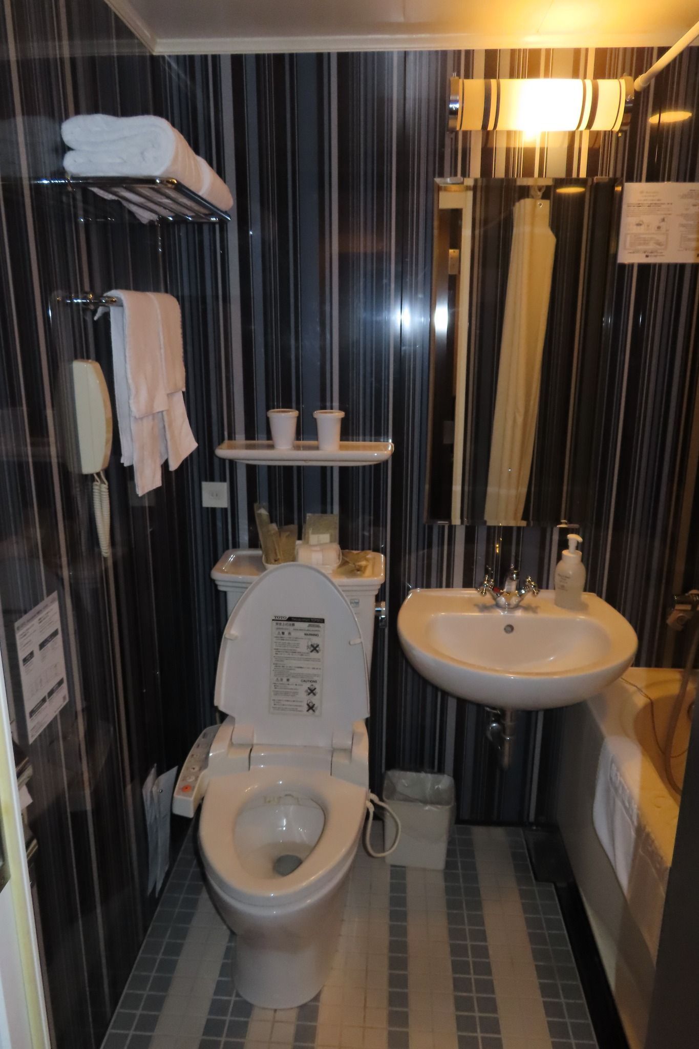A bathroom with a toilet , sink and mirror