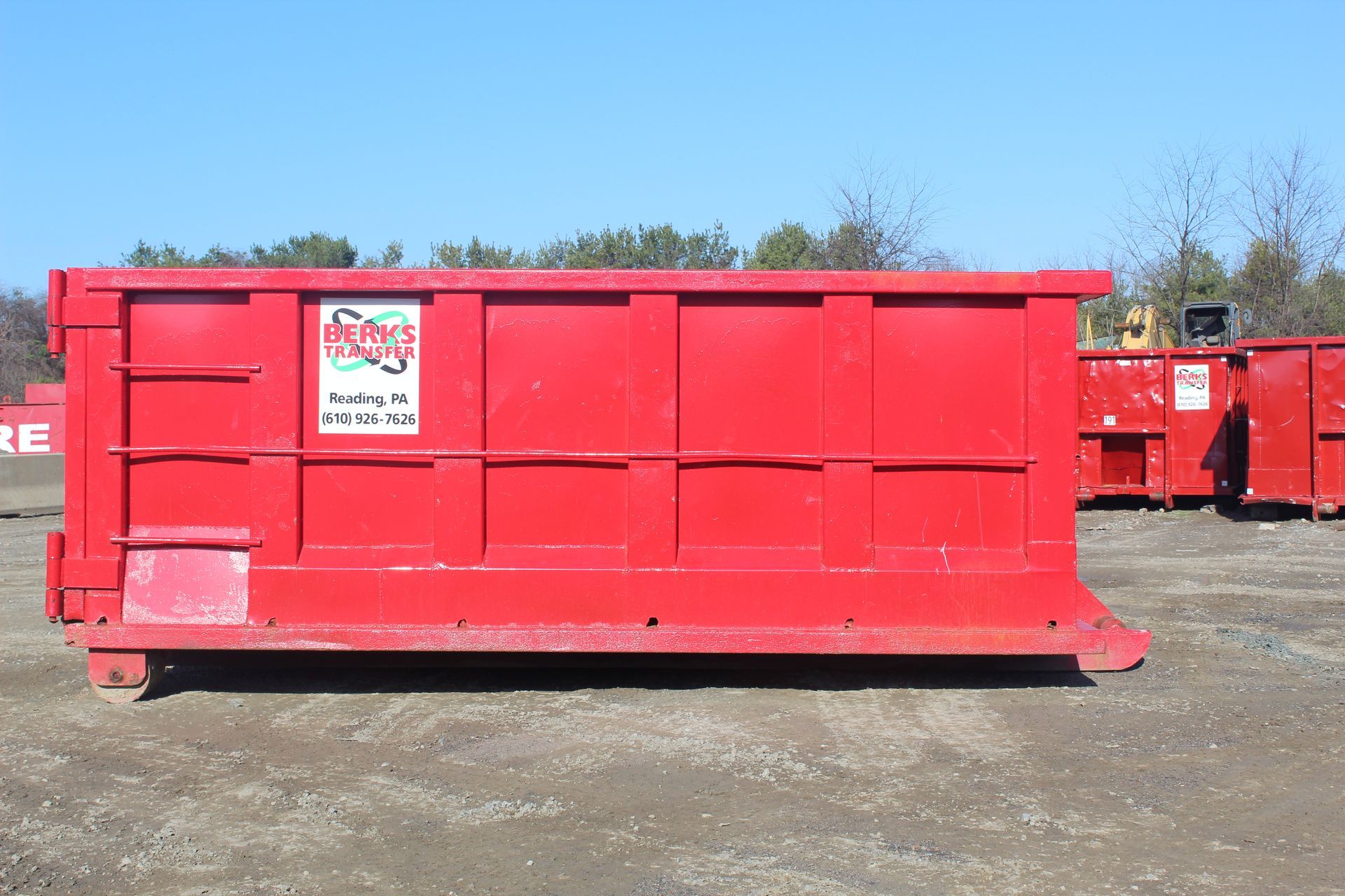 A large red dumpster with a Berks Transfer sign on it.