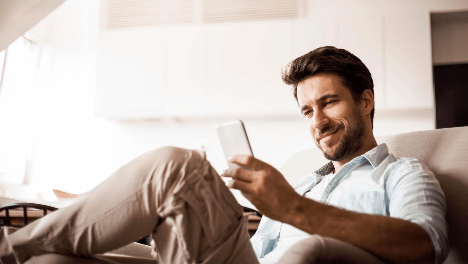 Picture of a man smiling at his phone.