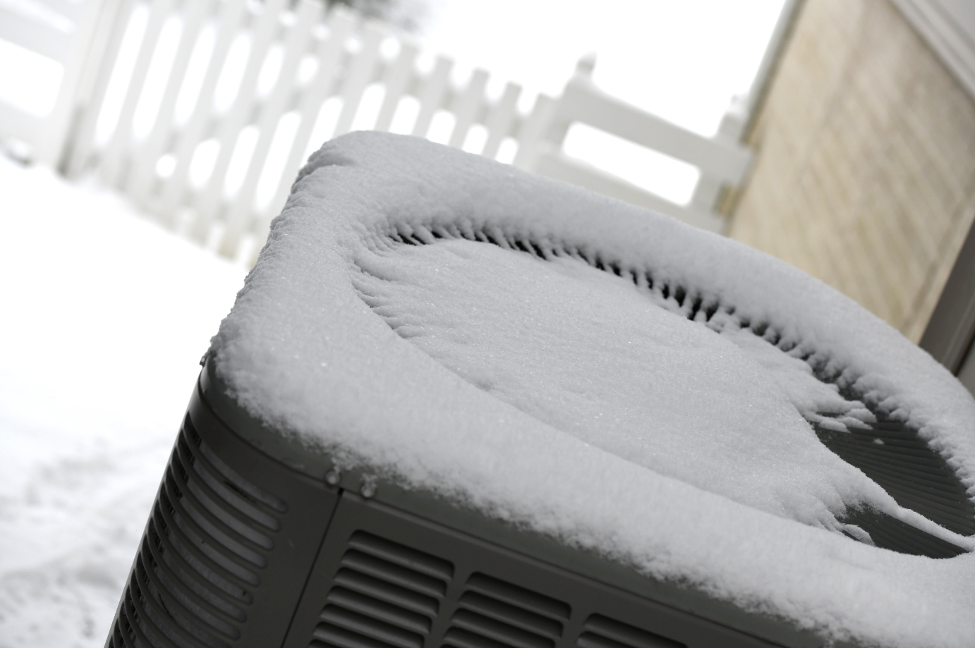 Fresh snow on top of a heat pump.