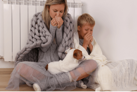 Picture of a mother, son and dog sitting on the floor cold.